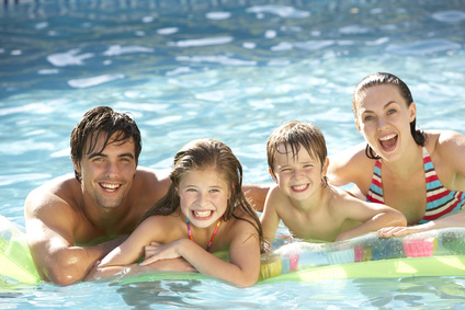 Junge Familie, die auf Luftmatratze im Pool relaxt