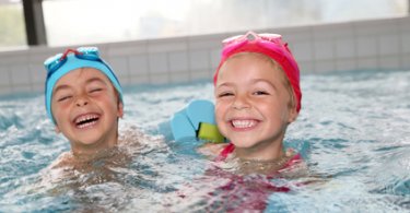 Junge und Mädchen haben Spass im Swimming Pool